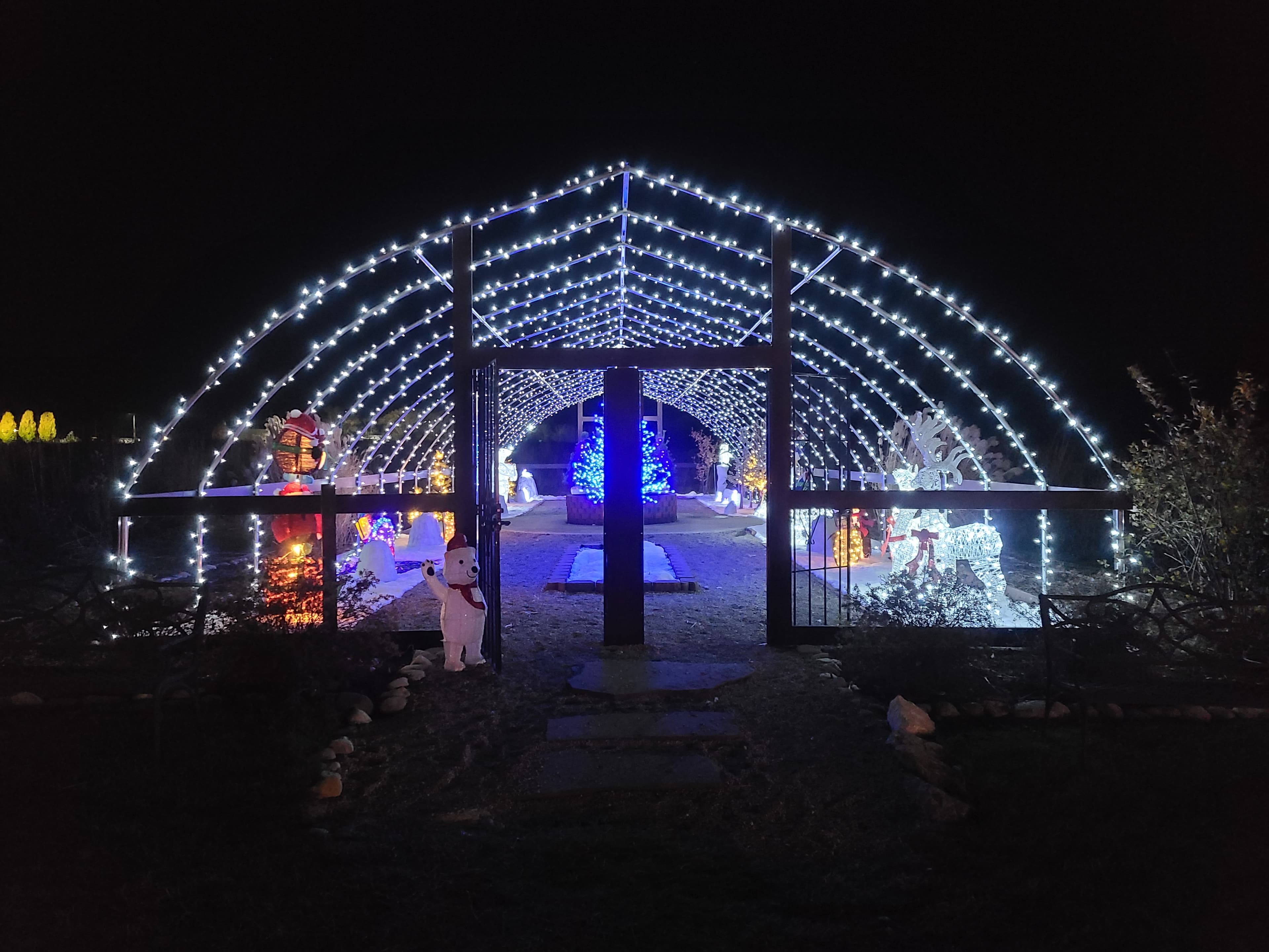 White-light holiday tunnel leading into an illuminated winter display