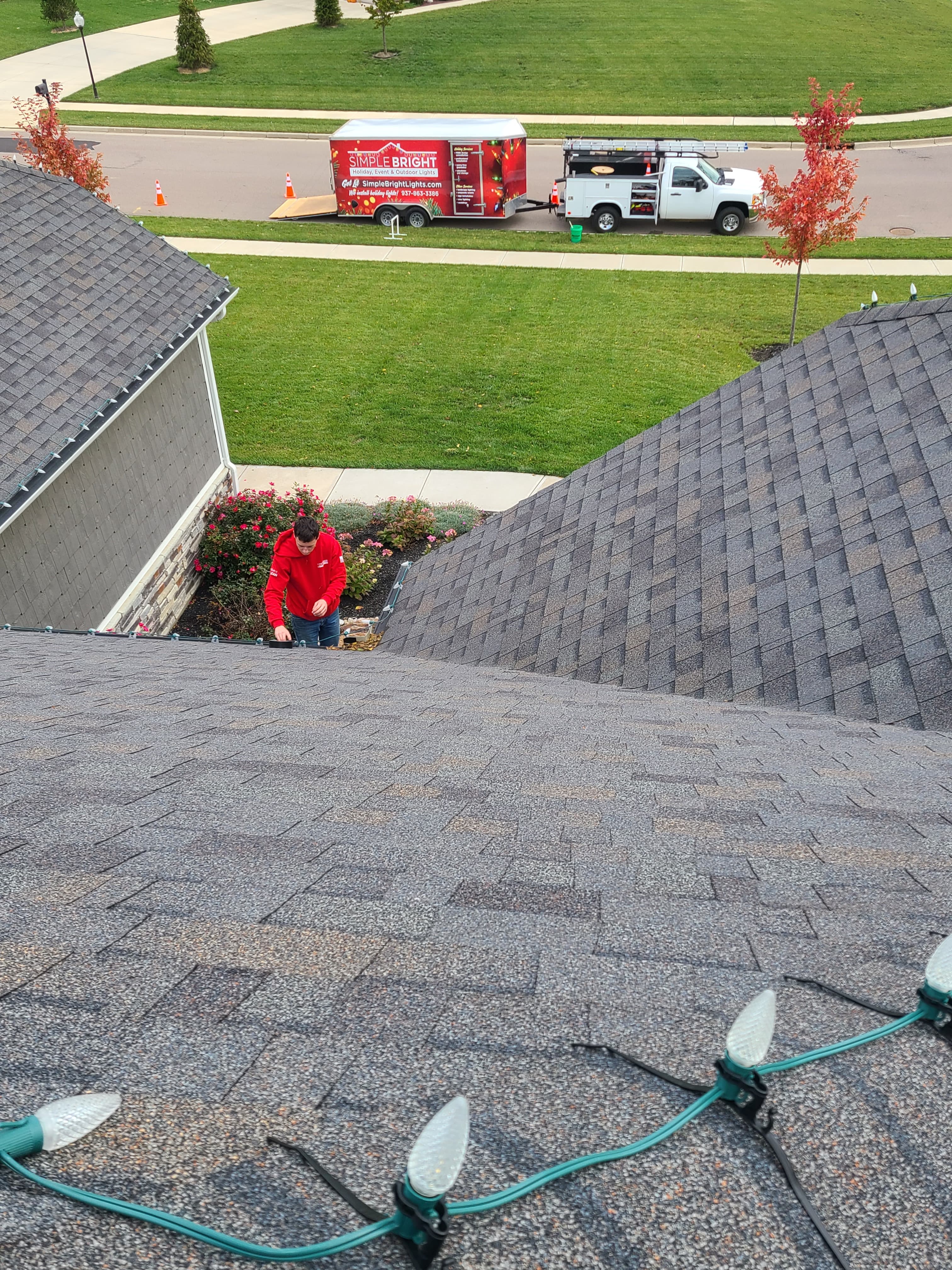 Residential holiday lights being custom-fit along a roofline