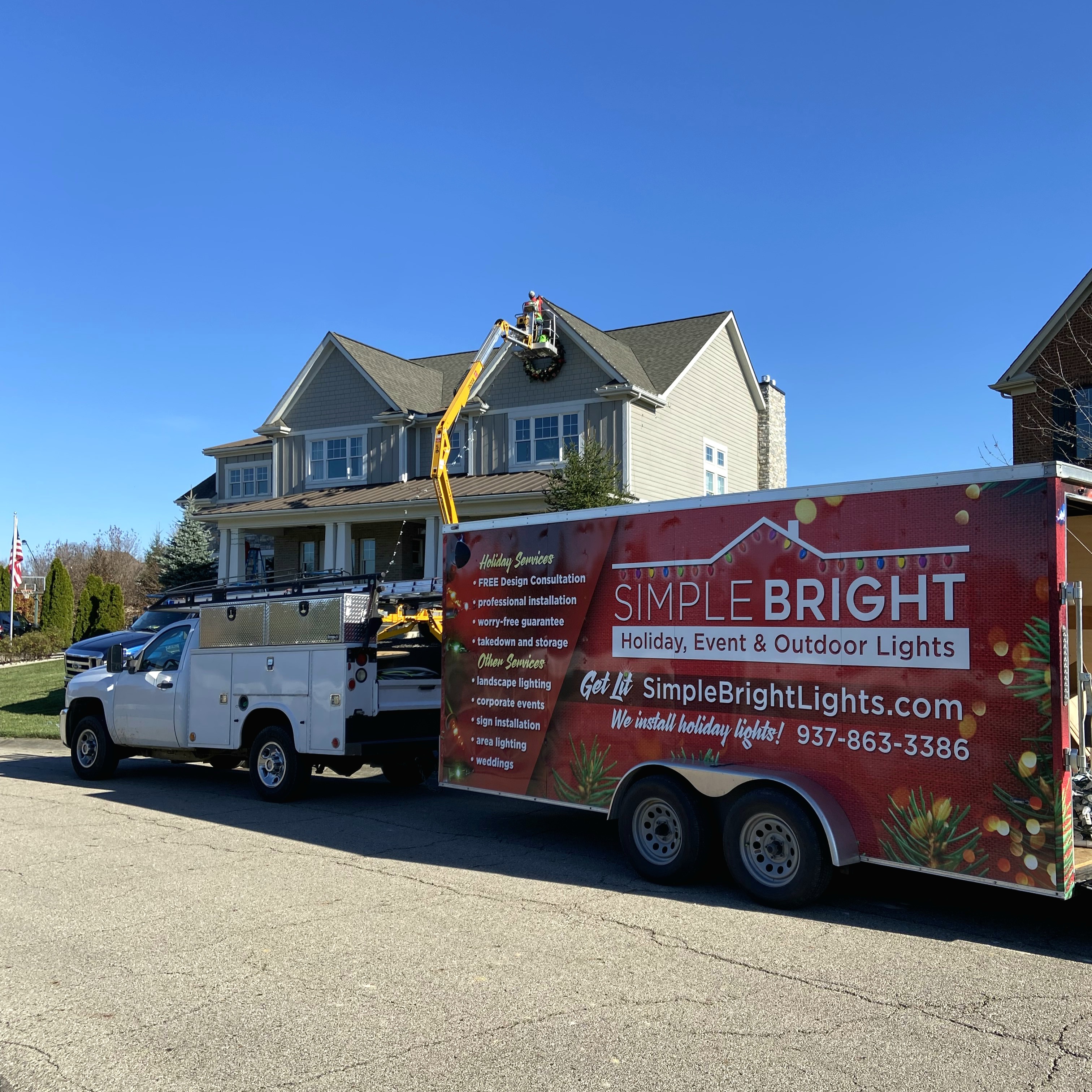 Simple Bright Lights crew and red trailer installing holiday lights at a home