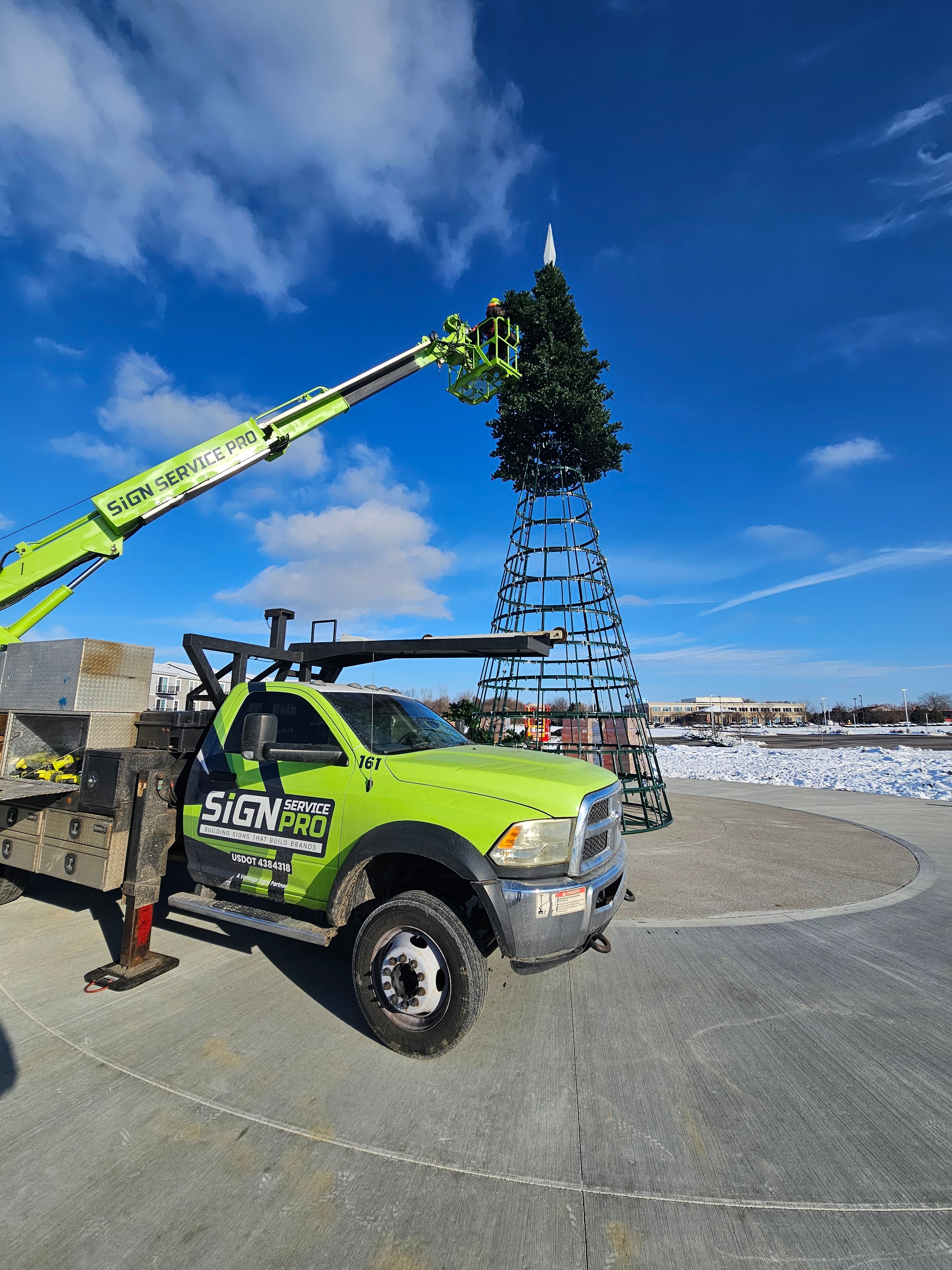 Sign Service Pro truck and aerial equipment beside the partially assembled tree